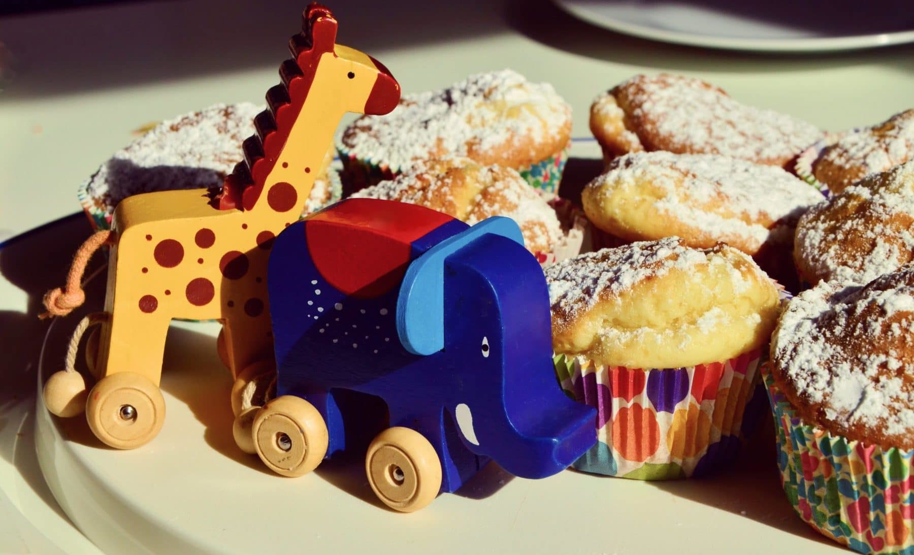 Muffins und Holzspielzeug auf einem Tisch zum Kindergeburtstag