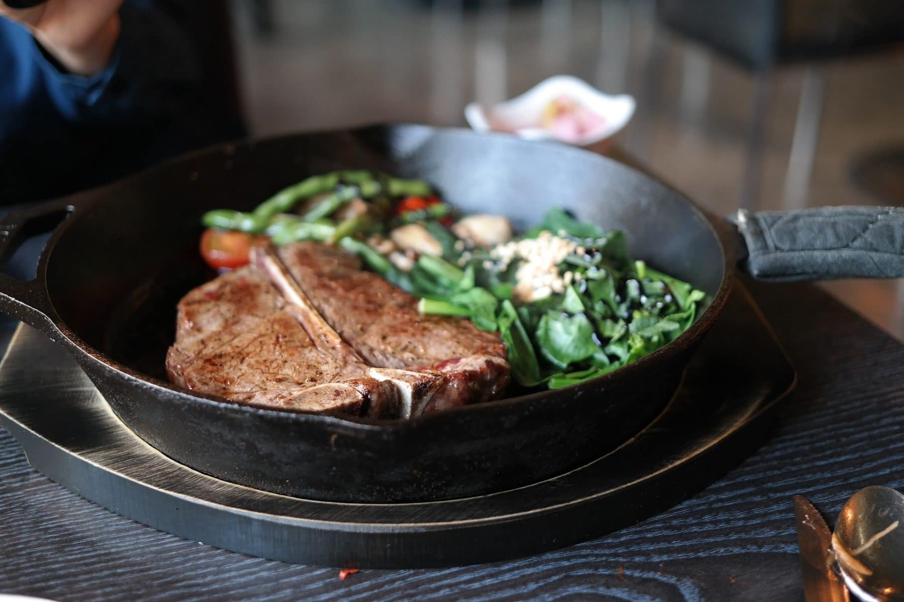 Gusseisenpfanne in Aktion mit Steak und Gemüse